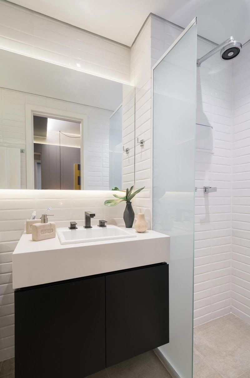Banheiros modernos com cerâmica metro white, móvel planejado e balcão.